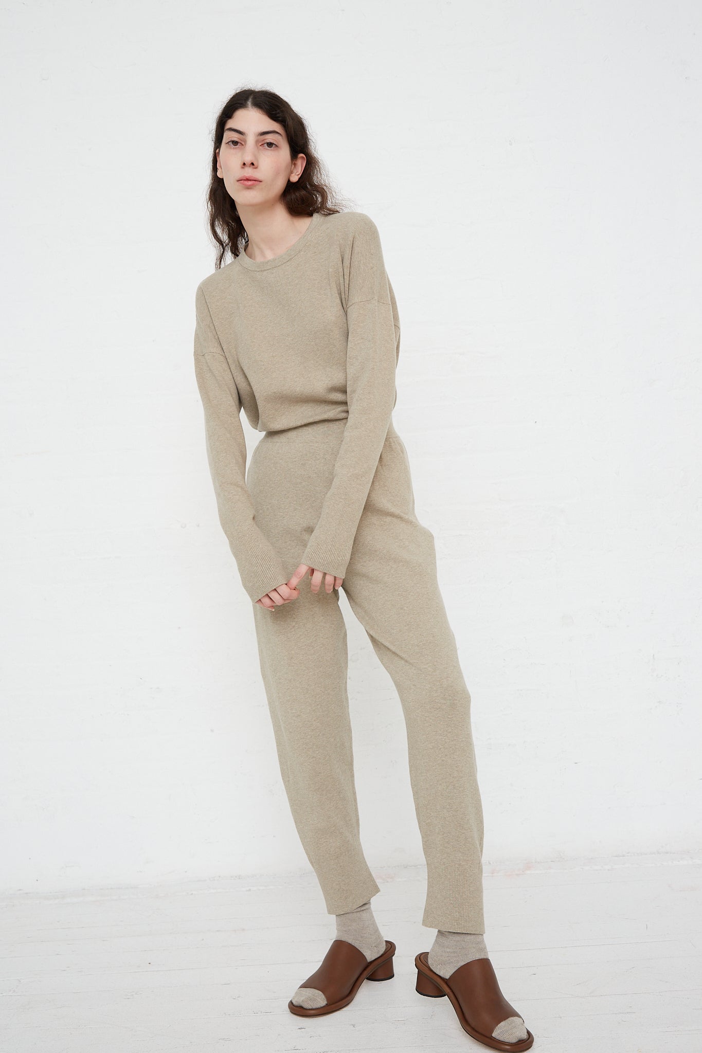 The model is wearing a beige sweater and soft Lauren Manoogian's Base Pant in Stone Melange. Front view and full length.