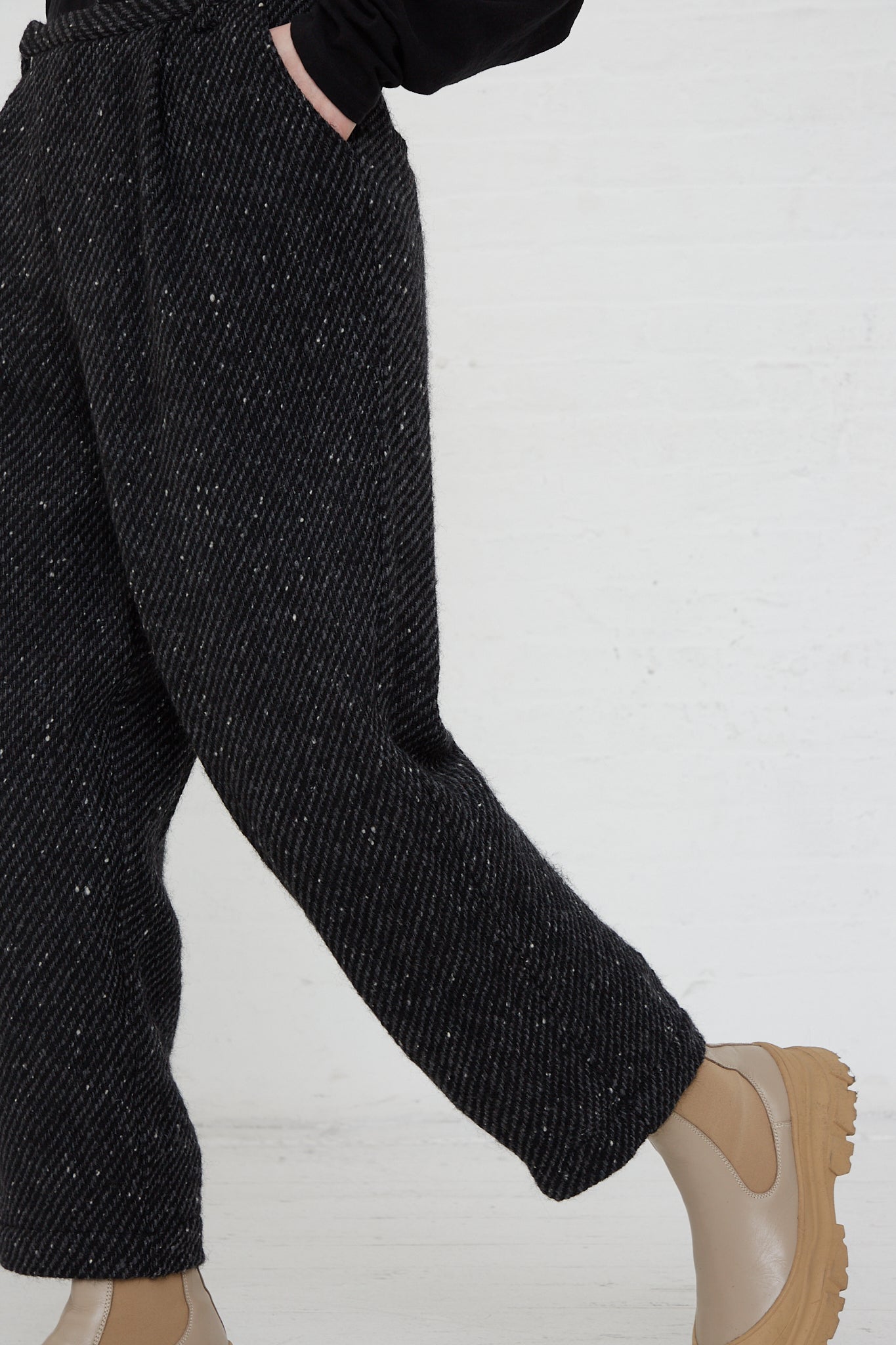 A woman donning a pair of Ichi Antiquités' Snow Nep Wool Pant in Black, with a relaxed fit, paired with brown boots.