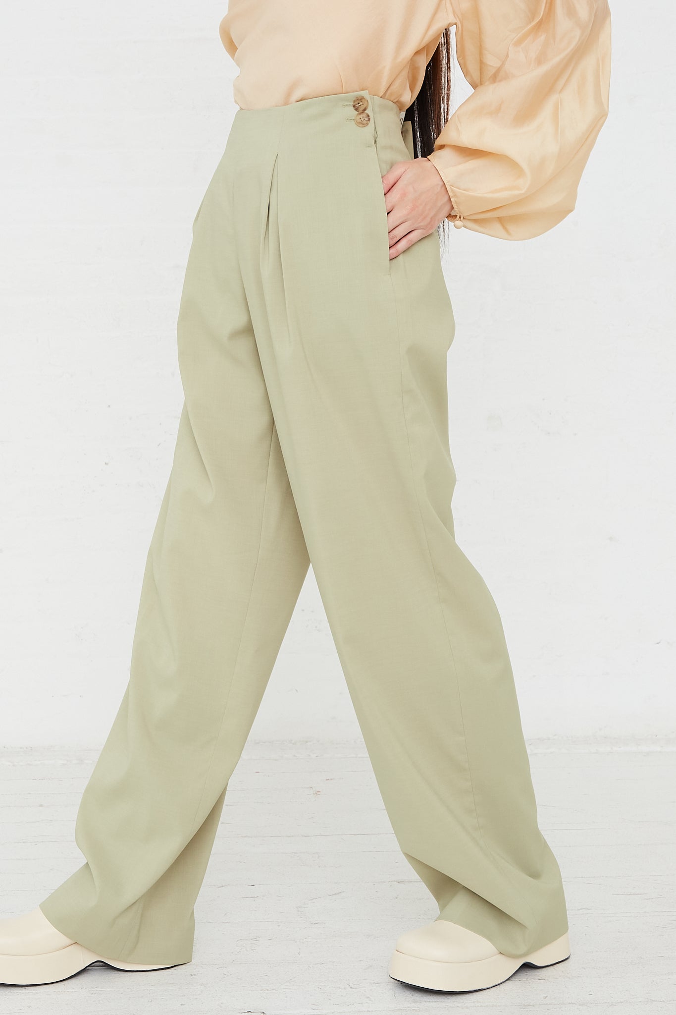 The model is wearing Rejina Pyo's Reine Trouser in Sage. Side view and full length.