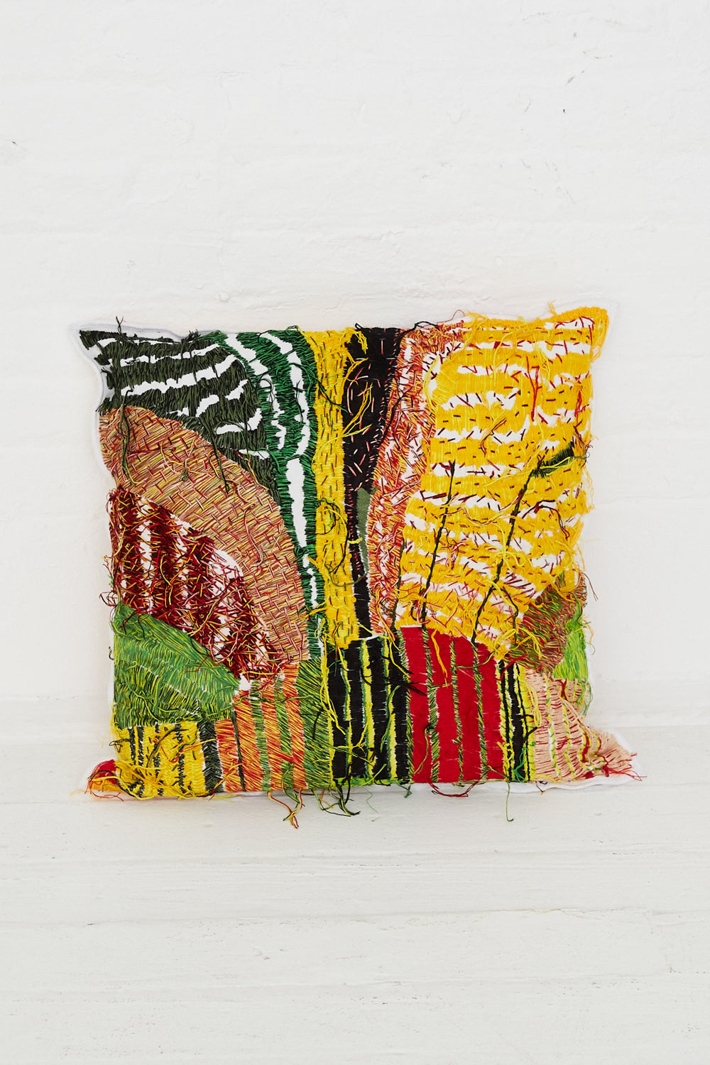 A Hand Embroidered Harvest Topographic Cushion by Luna Del Pinal with a colorful hand embroidery design on it.