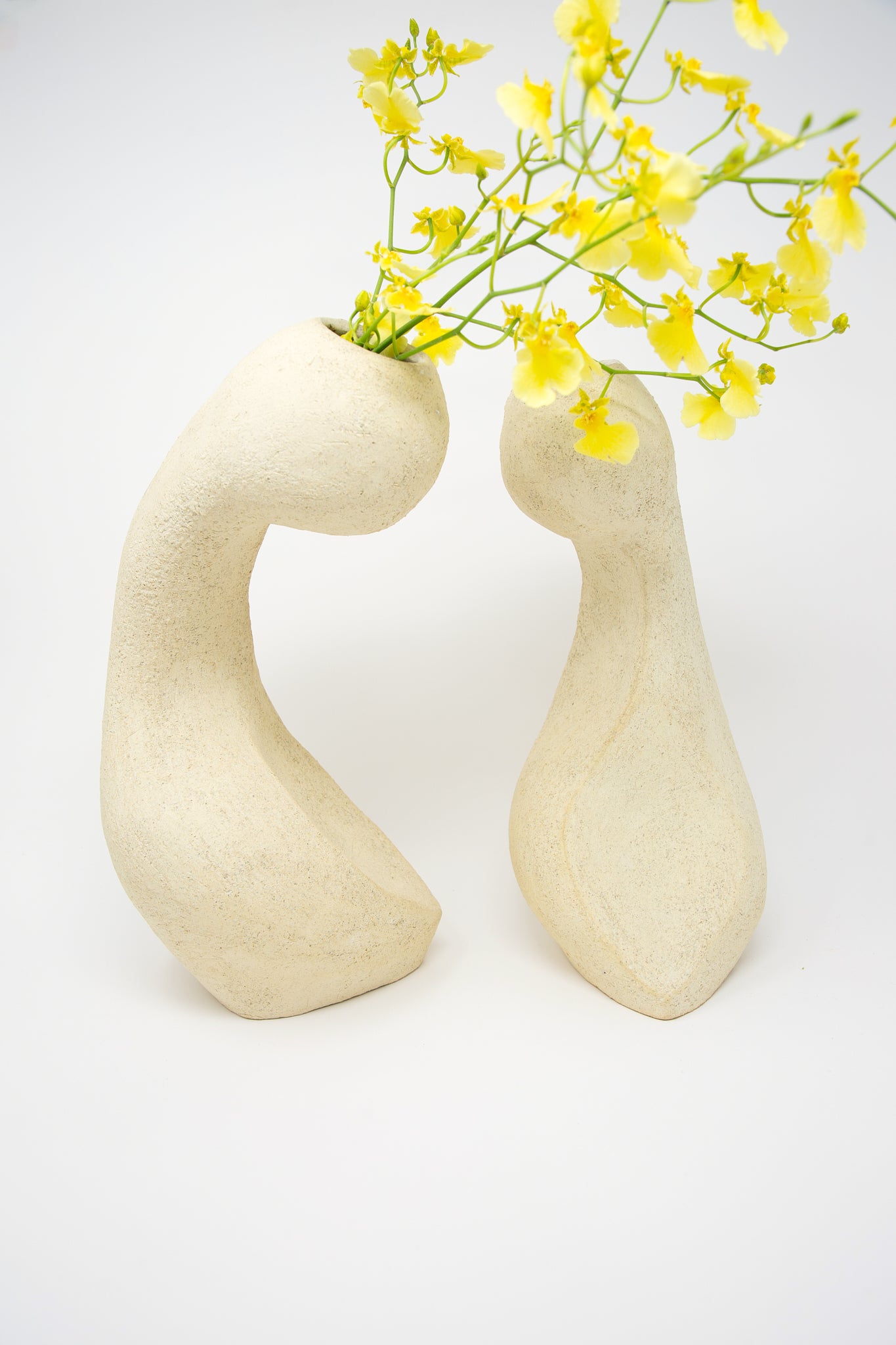 Abstract ceramic vessels with yellow flowers on a white background include the Large Hand Built Vessel No. 000711 Bud Vase by Lost Quarry.