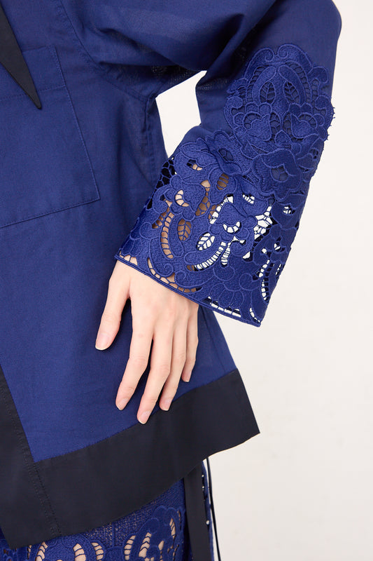 Close-up of a woman's hand resting on her hip, wearing a TOGA ARCHIVES Mesh Lace Shirt in Blue with relaxed fit and intricate detailing on the sleeve.