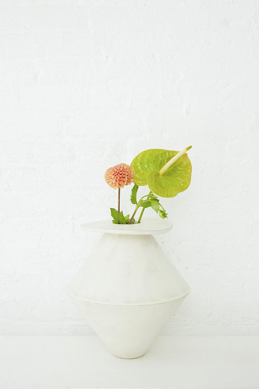 A Jumbo Diamond Vase in Cream by BZIPPY with a plant in it.