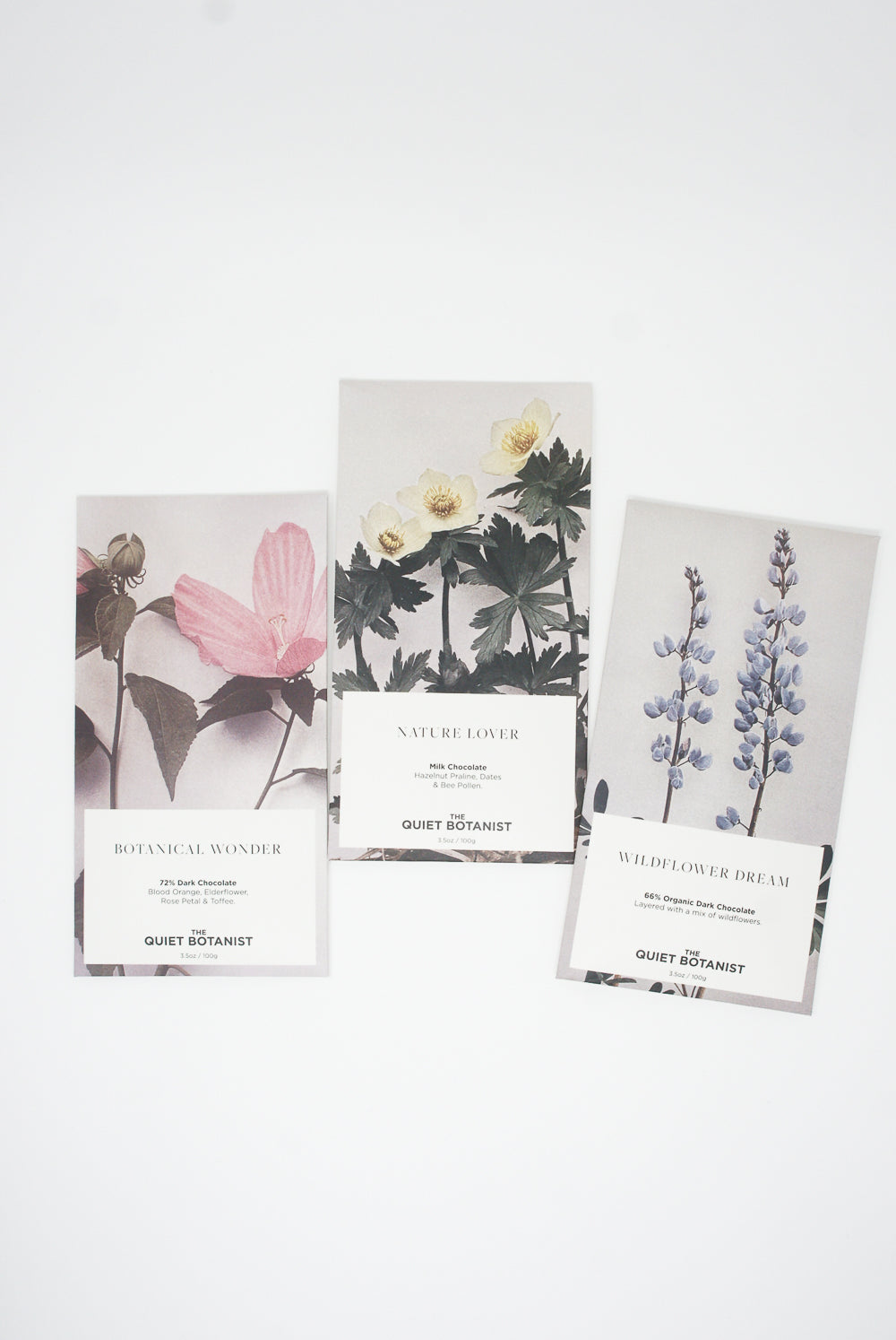 Three floral-themed bookmarks with Elderflower, Blood Orange, and Botanical Wonder Bar plant designs and titles displayed on a white background. Brand Name: The Quiet Botanist