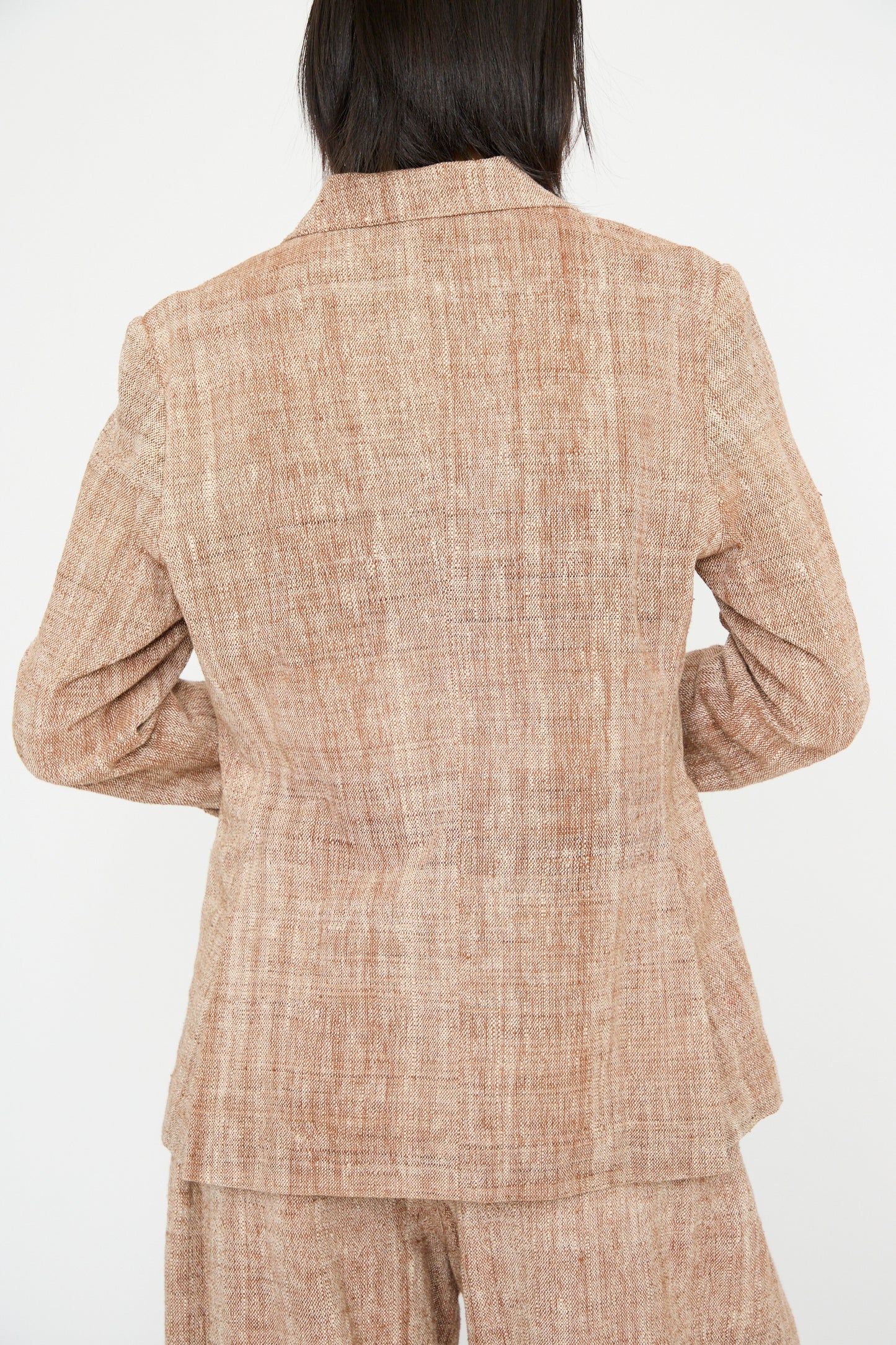 An individual wears 11.11's Cotton Blazer in Burnt Umber with a relaxed fit, captured from the back against a white background.