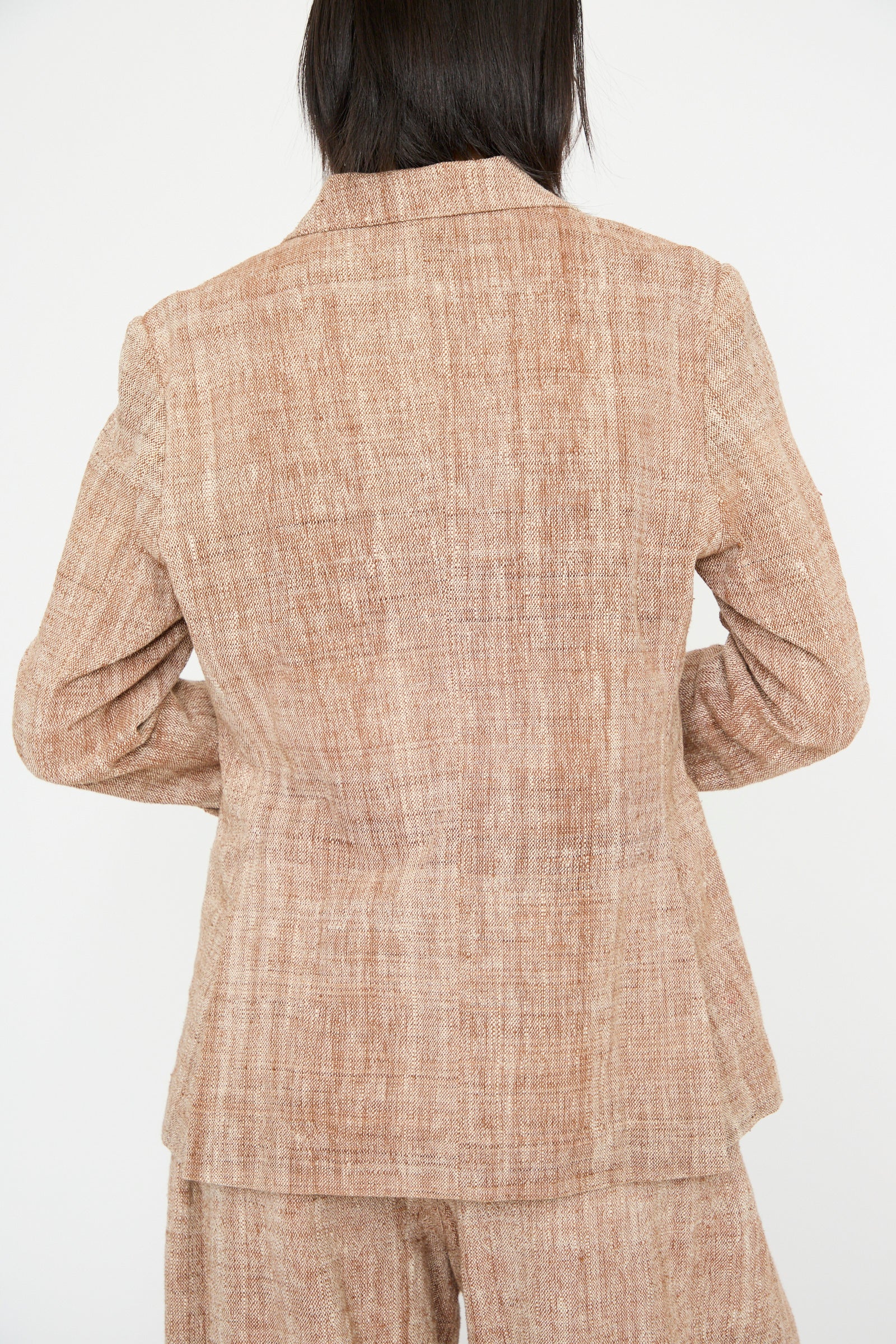 An individual wears 11.11's Cotton Blazer in Burnt Umber with a relaxed fit, captured from the back against a white background.