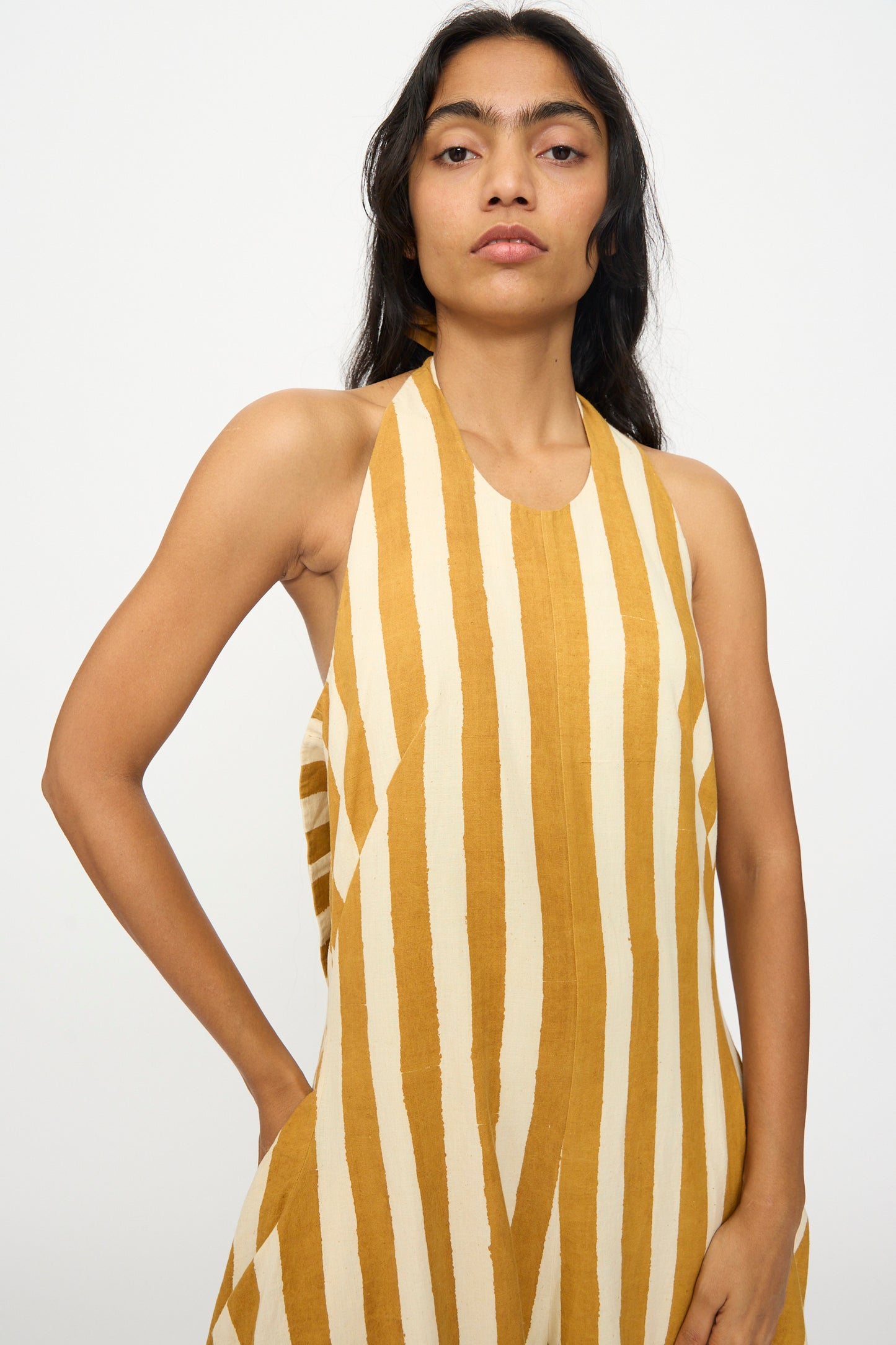 A person stands against a plain background wearing the 11.11 Cotton Stripe Jumpsuit in mustard yellow with vertical white stripes.