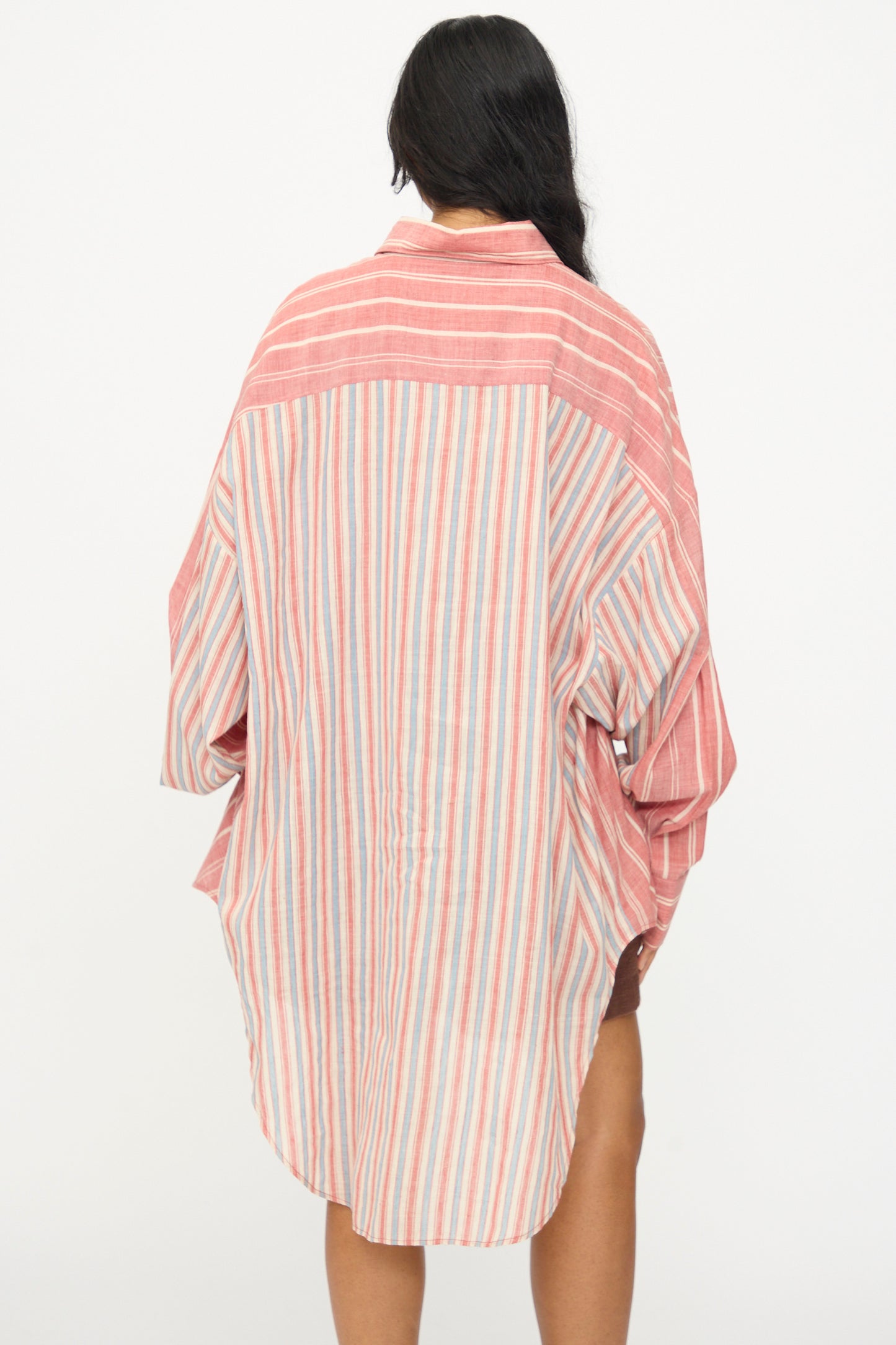 Person with long dark hair, seen from the back, wears the 11.11 Cotton Stripe Shirt in Multi—an oversized red and white striped cotton shirt—against a plain white background.