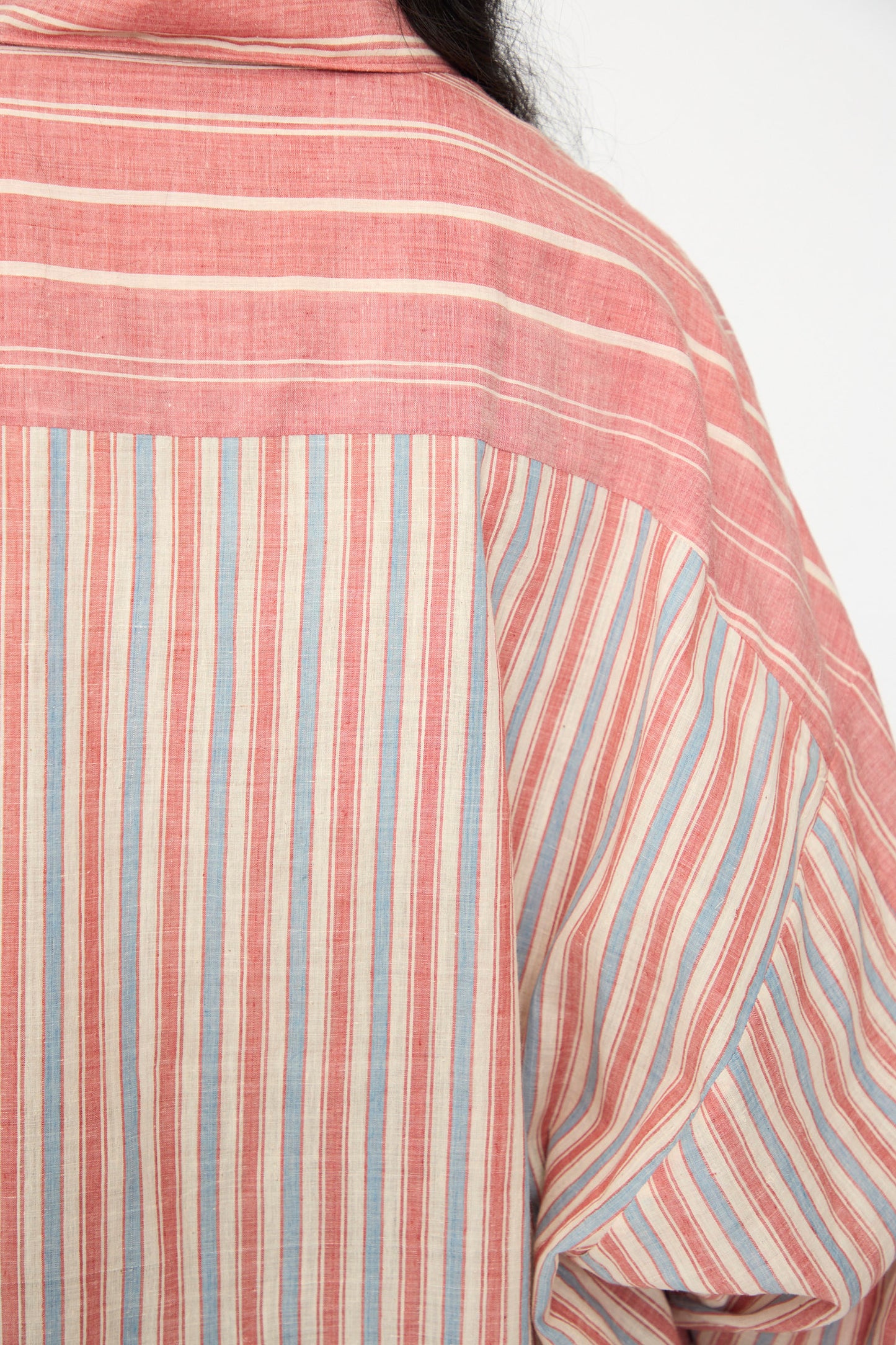 Close-up of the back of the 11.11 Cotton Stripe Shirt in Multi, an oversized cotton button-up with horizontal and vertical stripes in red, blue, and off-white tones. Made in India.