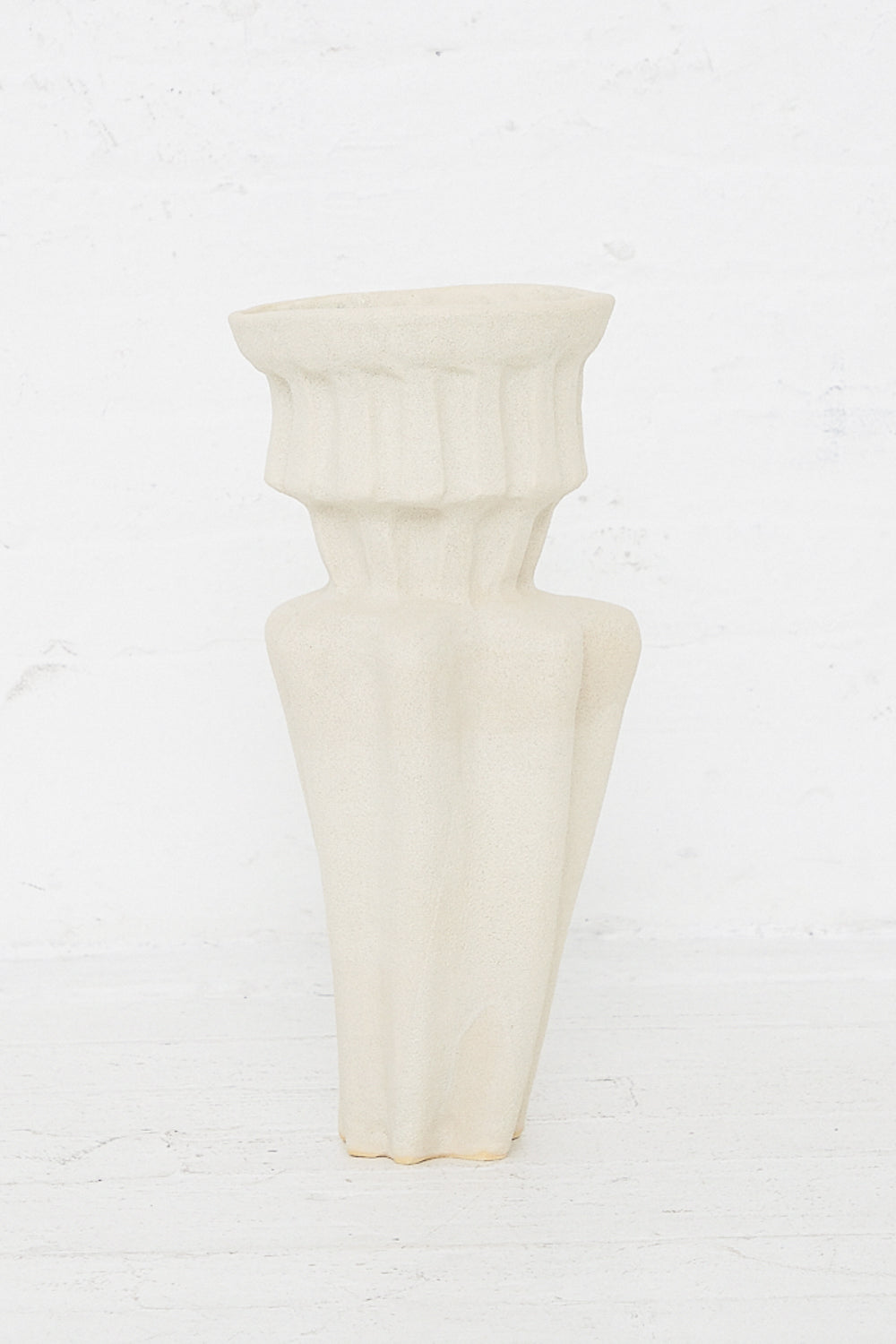 A Column Vessel in White by ANK Ceramics, a hand-built stoneware vessel with a white glaze, sitting on a white table.