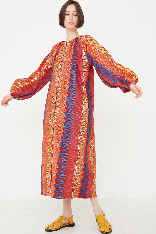 A woman in the Odile Jacobs Audrey Dress in Multi Orange/Yellow/Blue.