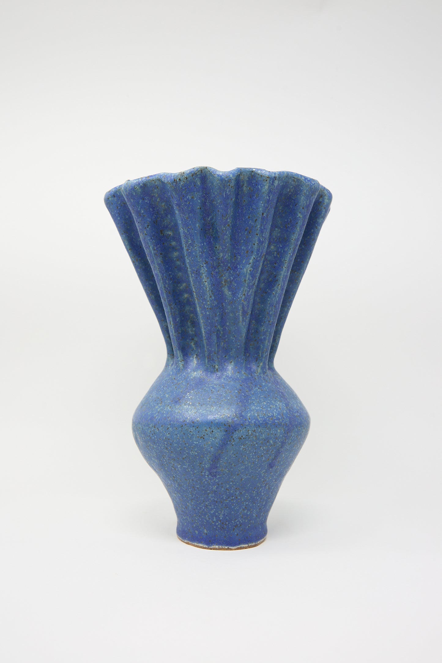 ANK Ceramics' Pleat Vase in Blue features a fluted top and a blue speckled glaze on a plain background.