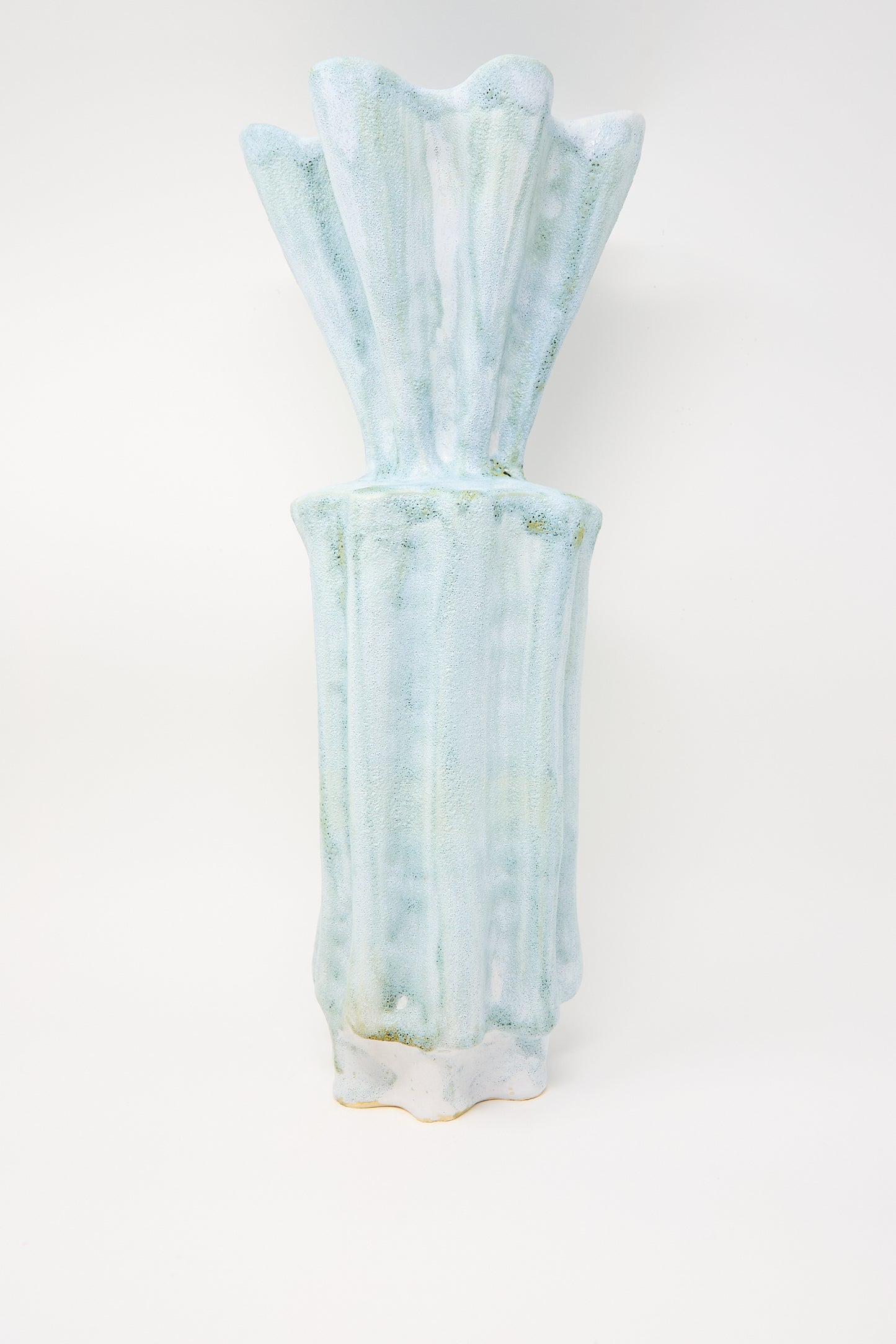 A Tall Watercolor Vessel by ANK Ceramics, crafted from stoneware, features a textured pale blue surface and a narrow fluted top.