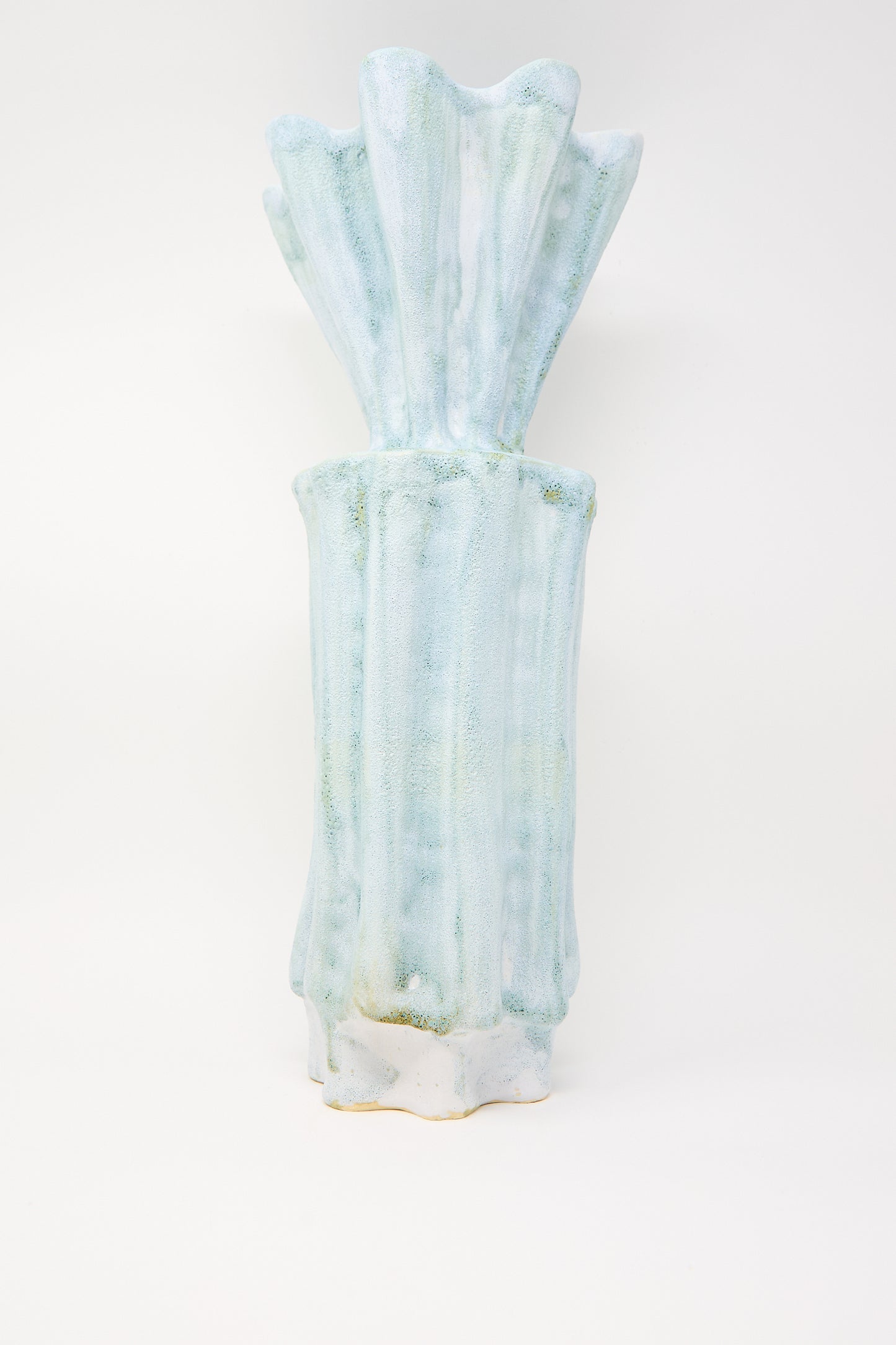 A tall vase with a watercolor design, featuring textured stoneware in light blue hues and a wavy abstract pattern, resembles ANK Ceramics' Tall Watercolor Vessel against a plain white background.