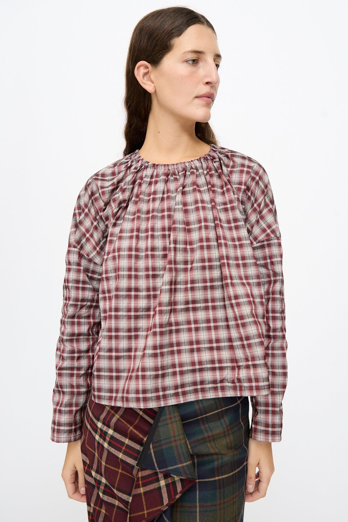 A person wearing the Bolla Shirt in Bordeaux Check that has a gathered neckline and boxy shape.