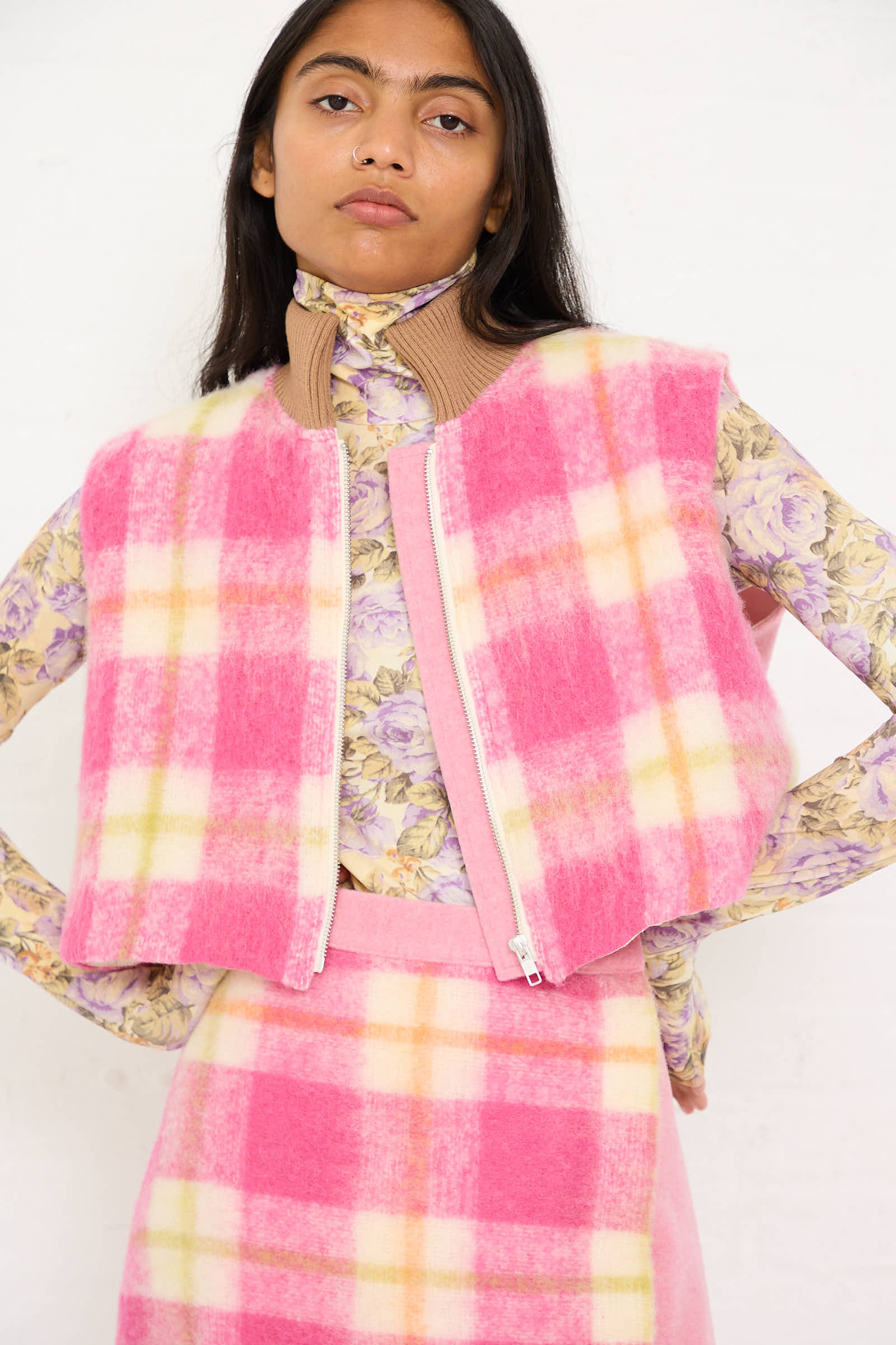 Individual wearing a Cool Bomber Jacket in White, Pink, and Green Check by AVN, posing with hands on hips.