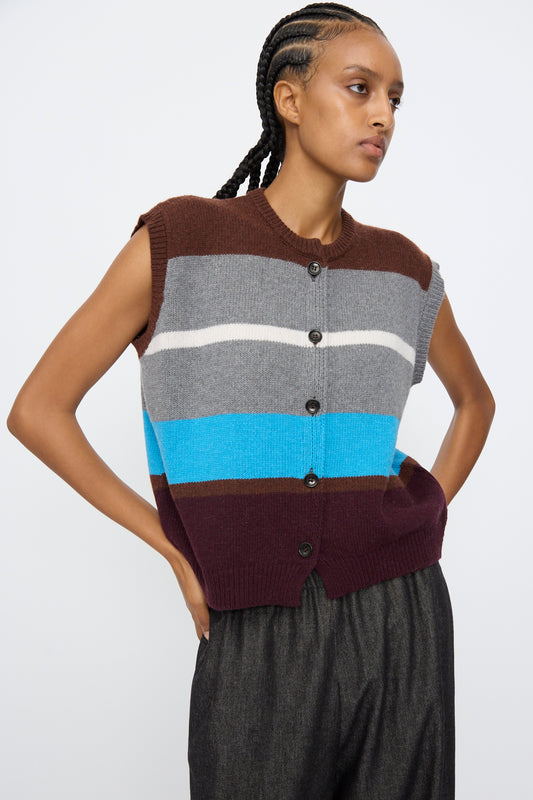 A person wears the AVN Funky Vest in Multicolor—a sleeveless, button-up wool blend vest with brown, grey, white, blue, and burgundy stripes—paired with dark pants.