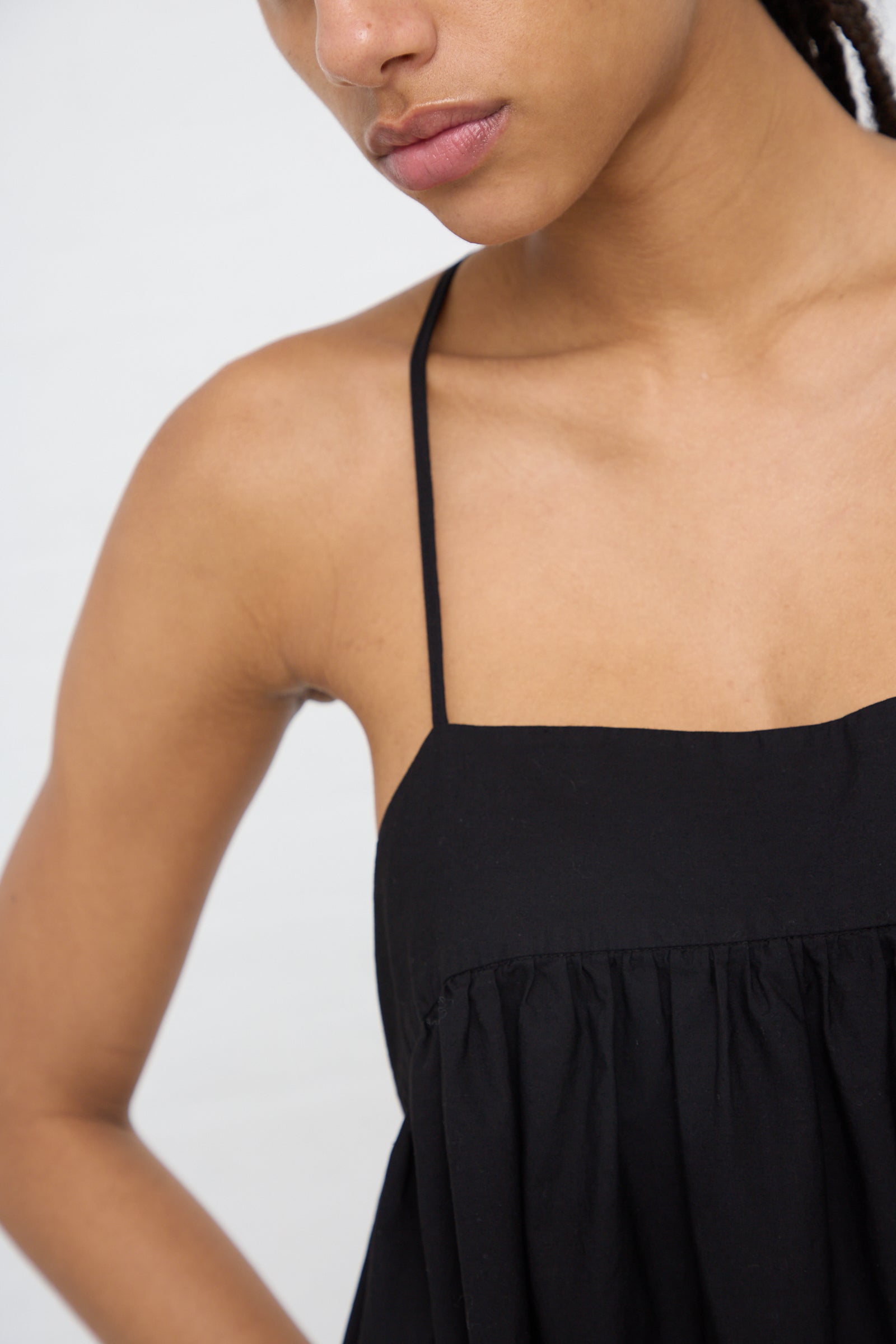 Close-up of a woman in AVN's Sun Sational Dress in Black with focus on her shoulder and neckline.