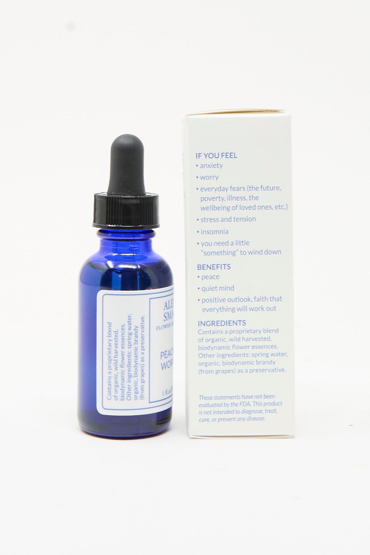 A blue glass dropper bottle of Alexis Smart Flower Remedies Peaceful Worrier next to its white cardboard box listing ingredients, usage, and benefits.