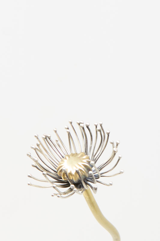 Handmade in NYC, this Sterling Silver and Brass Papaver No. 12 - II metal sculpture features a textured gold-colored center and silver-colored stamens on a curved stem.