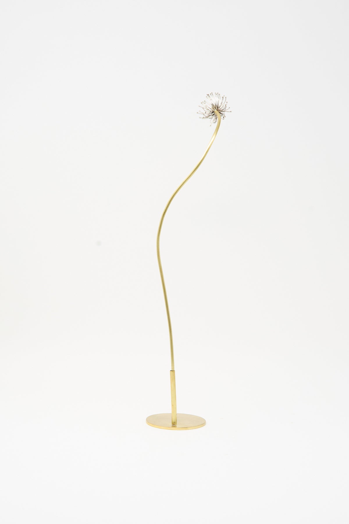 The Sterling Silver and Brass Papaver No. 12 - I features a thin, curved brass stem on a circular base, topped with a delicate silver Papaver flower head.