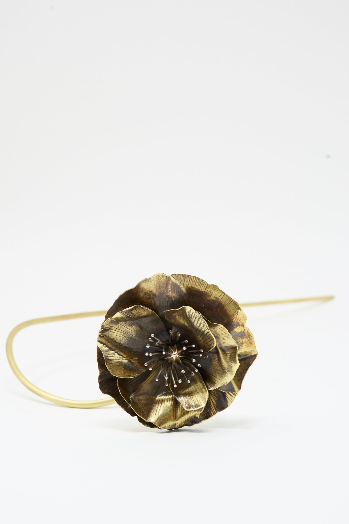 A close up of Alison Layton Sterling Silver and Brass Papaver No. 8, a metal sculpture shaped like a poppy with delicate silver stamens.