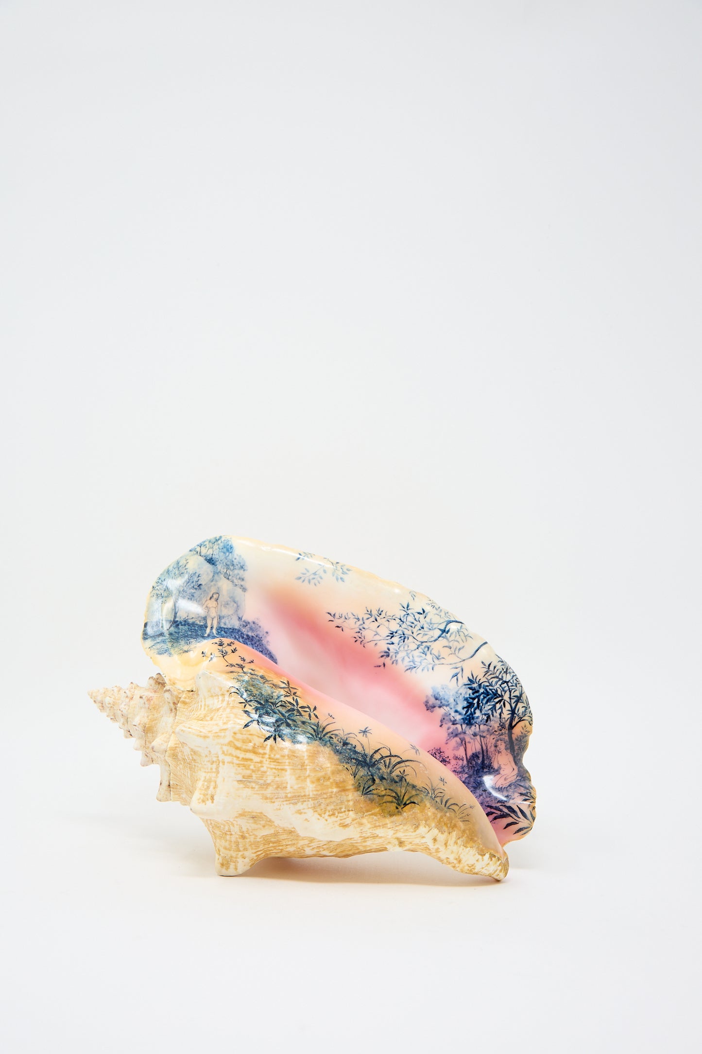 A large Hand Painted Conch I from Alyssa Goodman, featuring intricate blue and pink designs that depict trees and a landscape, reminiscent of hand-painted artistry.