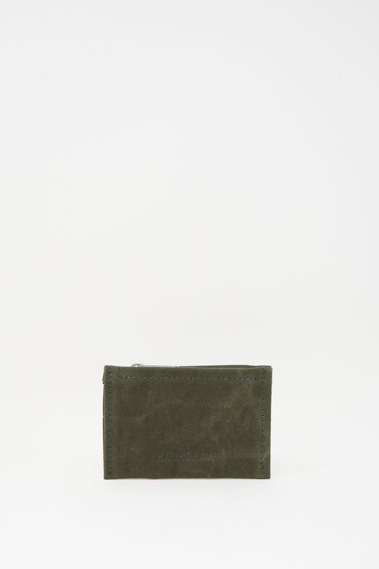 The Amiacalva Washed Canvas Small Pouch in Olive is a compact, rectangular pouch with a washed canvas finish and zipper top, shown standing upright against a plain white background.