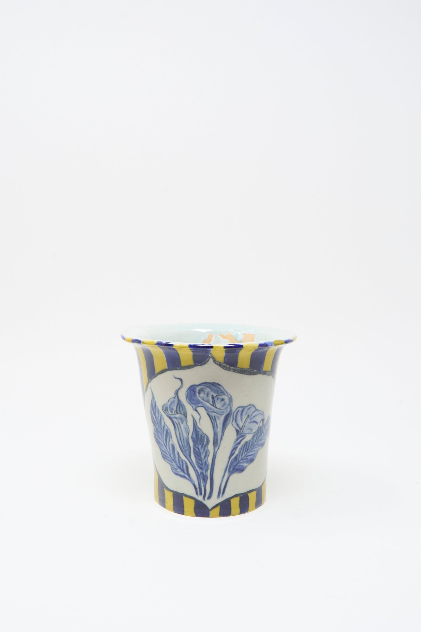 The Ariel Clute Hand Painted Floral Vessel is handmade in California from porcelain, featuring yellow and blue vertical stripes with a bold blue floral design on the front, photographed on a plain white background.