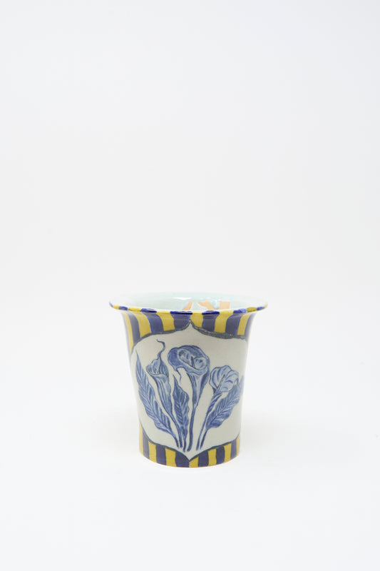 The Ariel Clute Hand Painted Floral Vessel is handmade in California from porcelain, featuring yellow and blue vertical stripes with a bold blue floral design on the front, photographed on a plain white background.