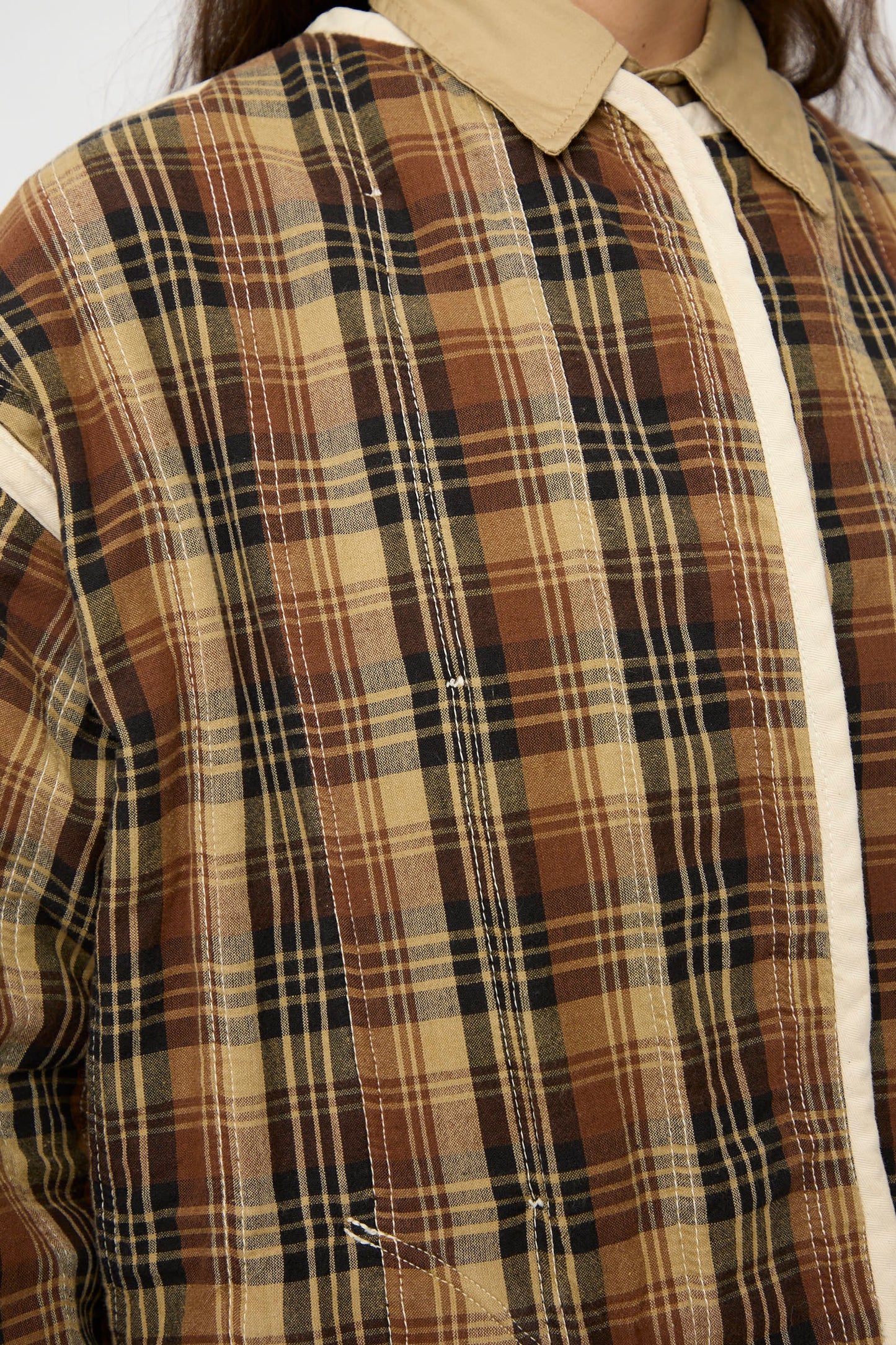 Close-up of a person wearing the As Ever Quilt Coat in HBT Natural, featuring an oversized fit with a beige collar and cream-colored vertical trim.