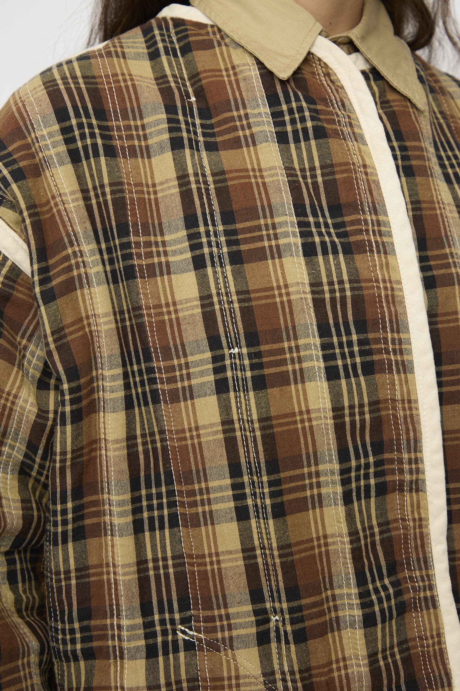 Close-up of a person wearing the As Ever Quilt Coat in HBT Natural, featuring an oversized fit with a beige collar and cream-colored vertical trim.