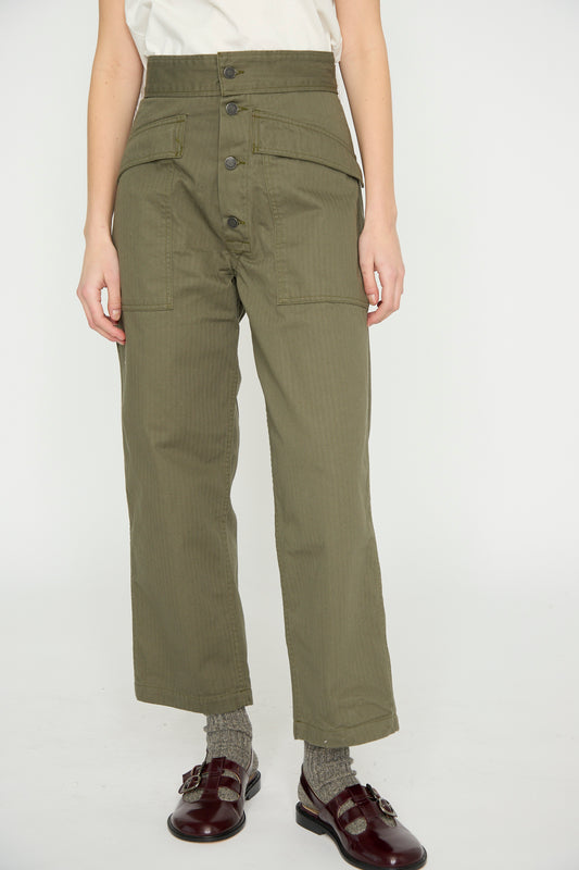 Wearing the Tanker in Olive from As Ever, styled with burgundy shoes and gray socks, creates a relaxed fit look with its high waist, large front pockets, and button details.