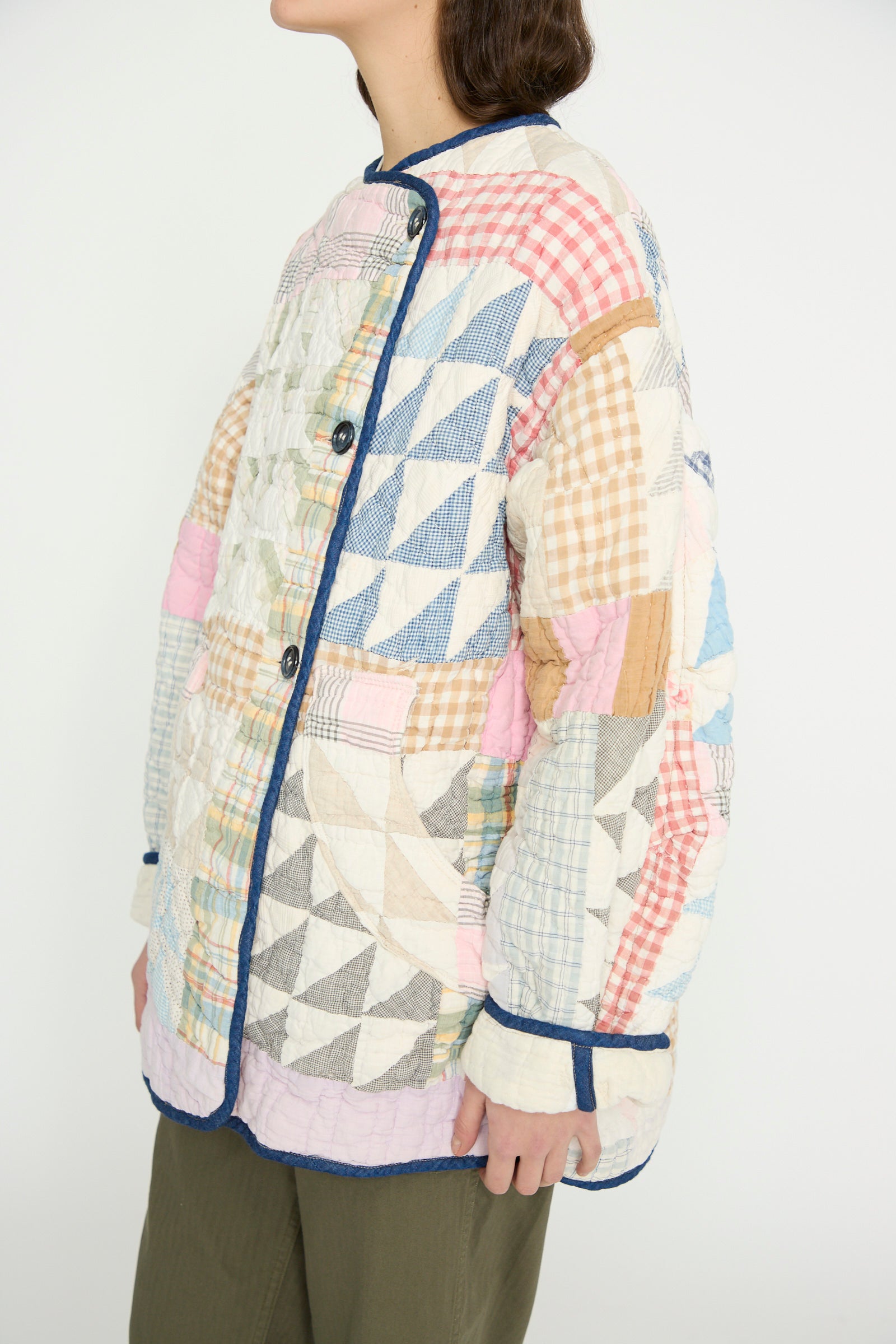 A person is wearing the As Ever Vintage Quilt Coat in Multi Color, paired with green pants, and is facing slightly to the left.