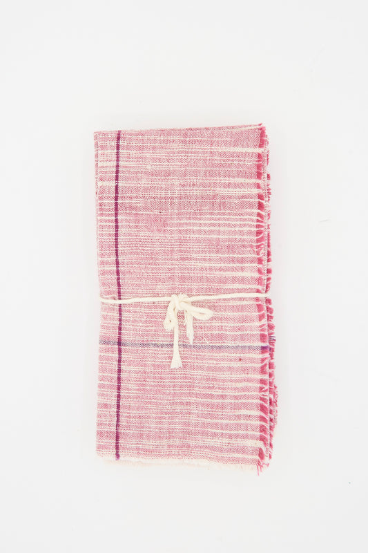Auntie Oti's Cotton Khadi Set of 6 Napkins in Pink Space Dye features handwoven pink and white napkins with fringed edges, tied with a cream string and placed against a white background.