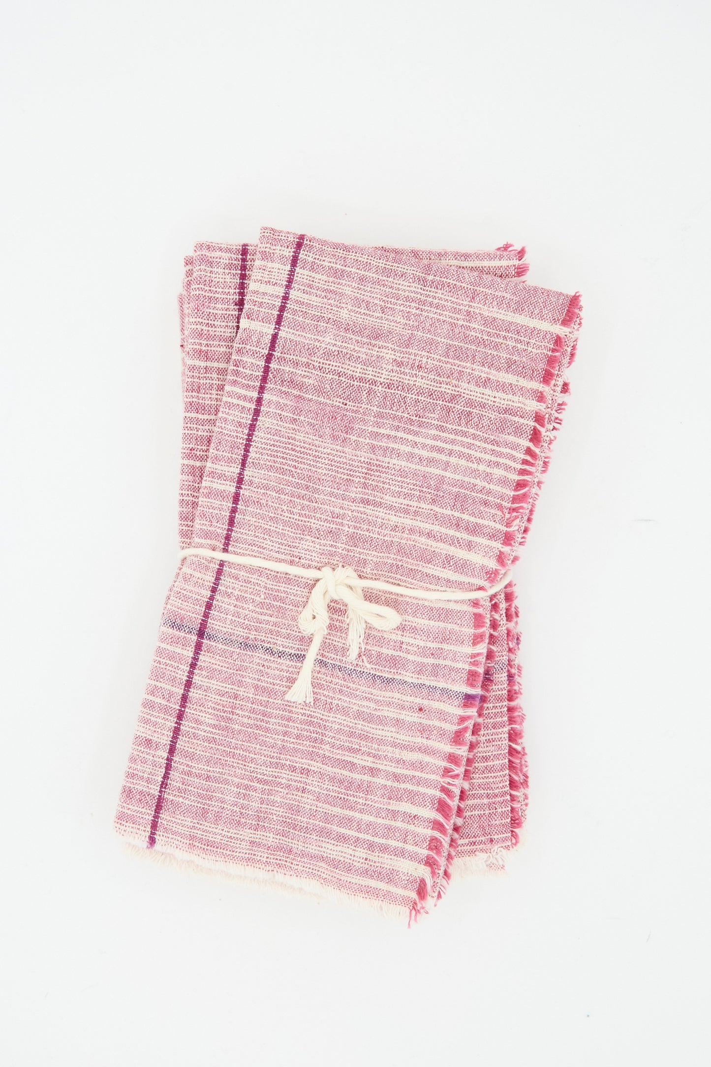 Auntie Oti's Cotton Khadi Set of 6 Napkins in Pink Space Dye is bundled together with white string and displayed on a white background.