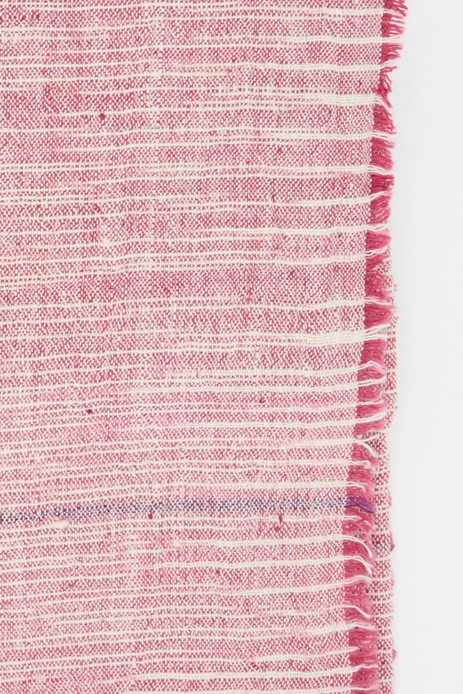 Close-up of an Auntie Oti Cotton Khadi Set of 6 Napkins in Pink Space Dye, featuring pink and white stripes with a fringed right edge.