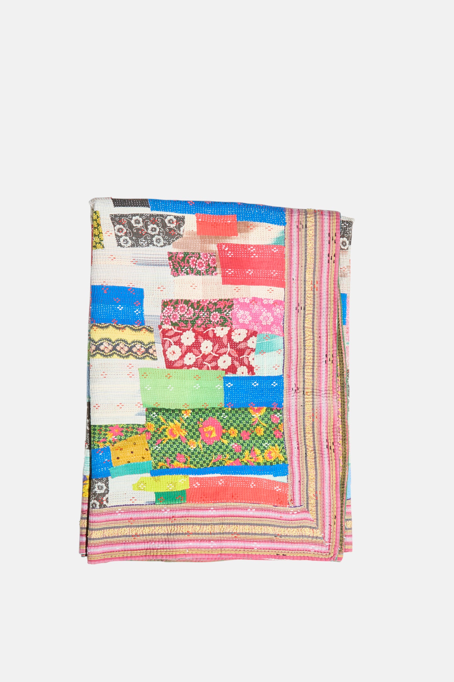 The One of a Kind Vintage Kantha Quilt IV by Auntie Oti is a folded handmade quilt with a patchwork of multicolored, patterned fabric strips—floral and geometric prints—on a white background.