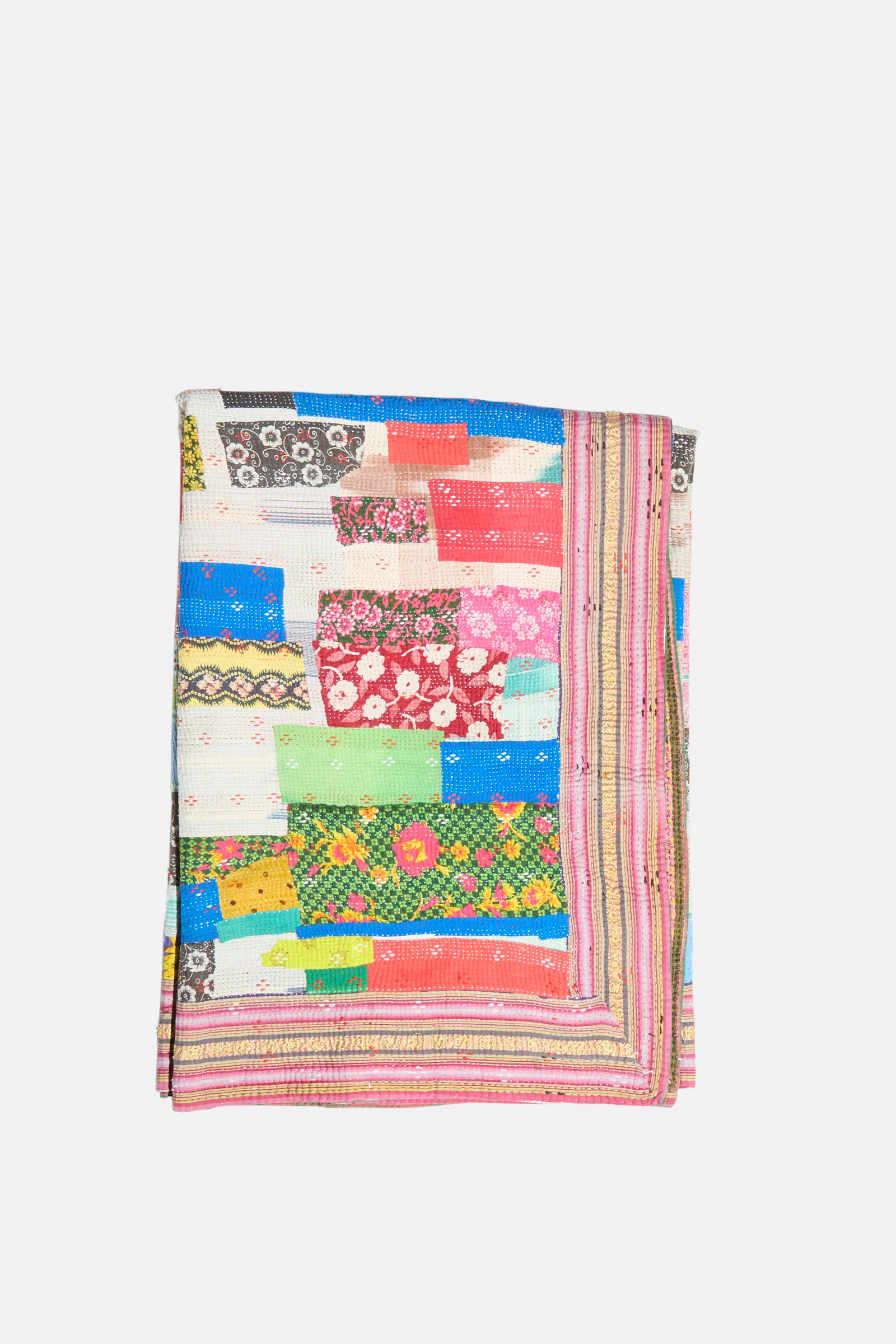 The One of a Kind Vintage Kantha Quilt IV by Auntie Oti is a folded handmade quilt with a patchwork of multicolored, patterned fabric strips—floral and geometric prints—on a white background.