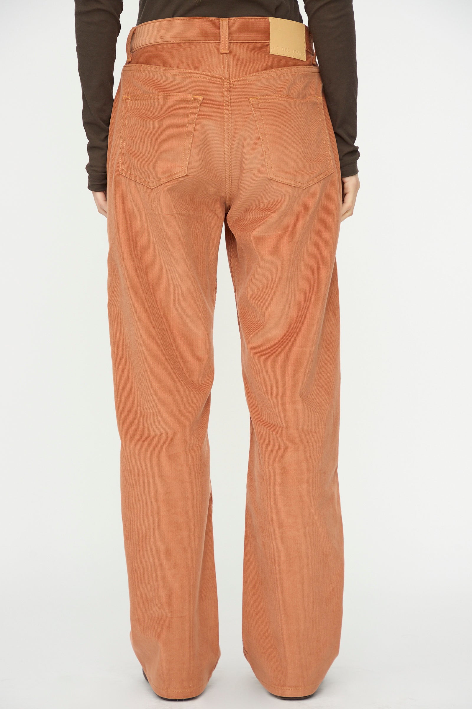 A person wearing the B Sides Bec Jean in Peach Tile, photographed from the back against a plain white background.