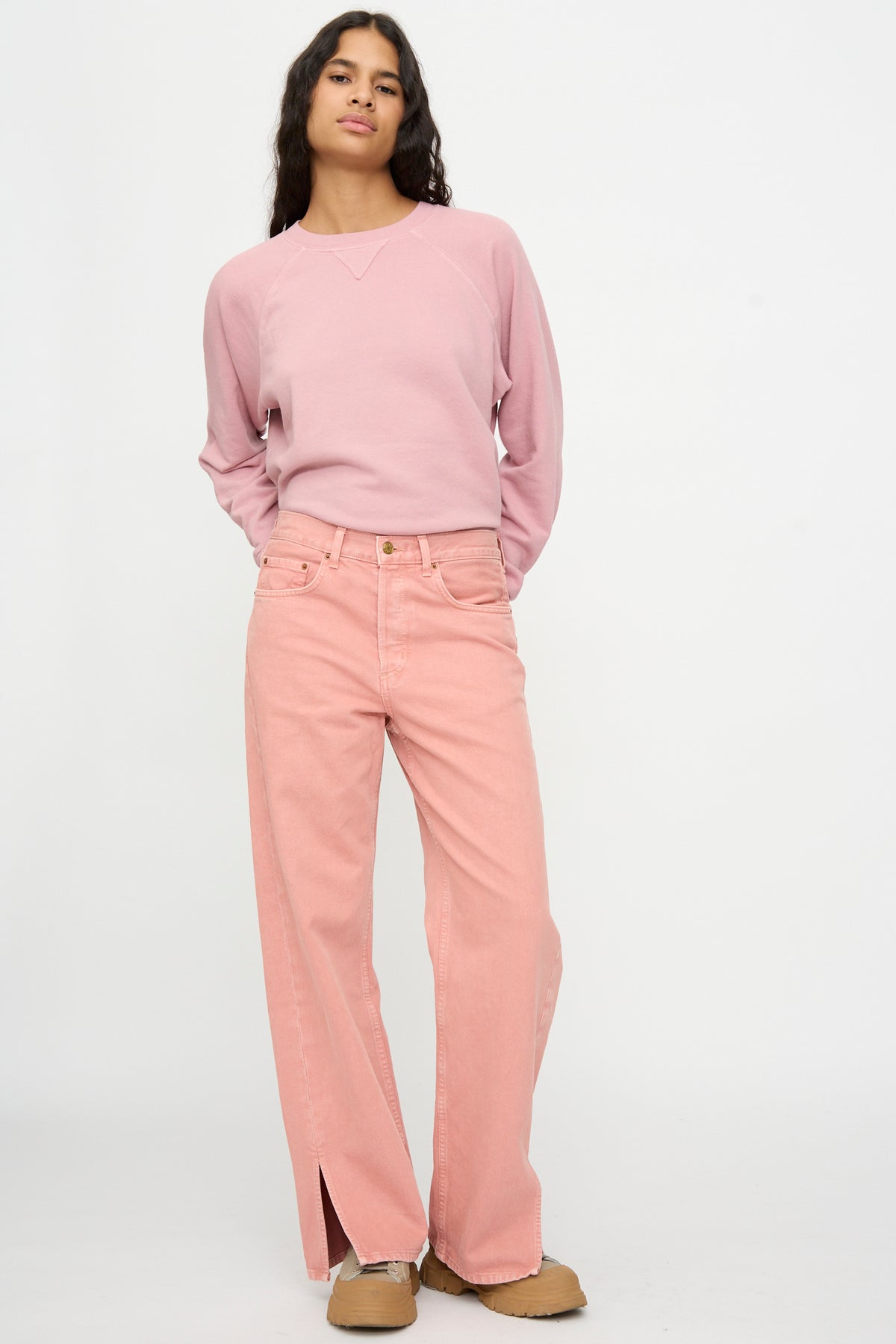 Person stands against a plain background wearing a pink long-sleeve shirt, tan shoes, and B Sides Charlot Split Hem in Myra Pink Overdye.