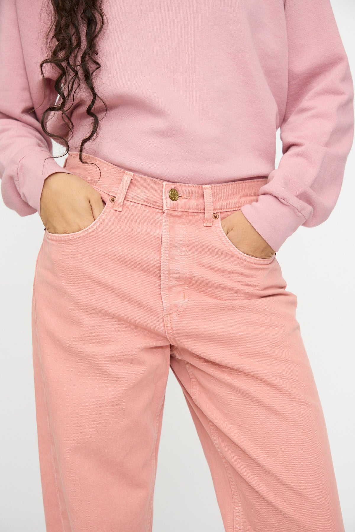 Model wears B Sides Charlot Split Hem in Myra Pink Overdye, hands in pockets, shown from shoulders to knees against a plain background.