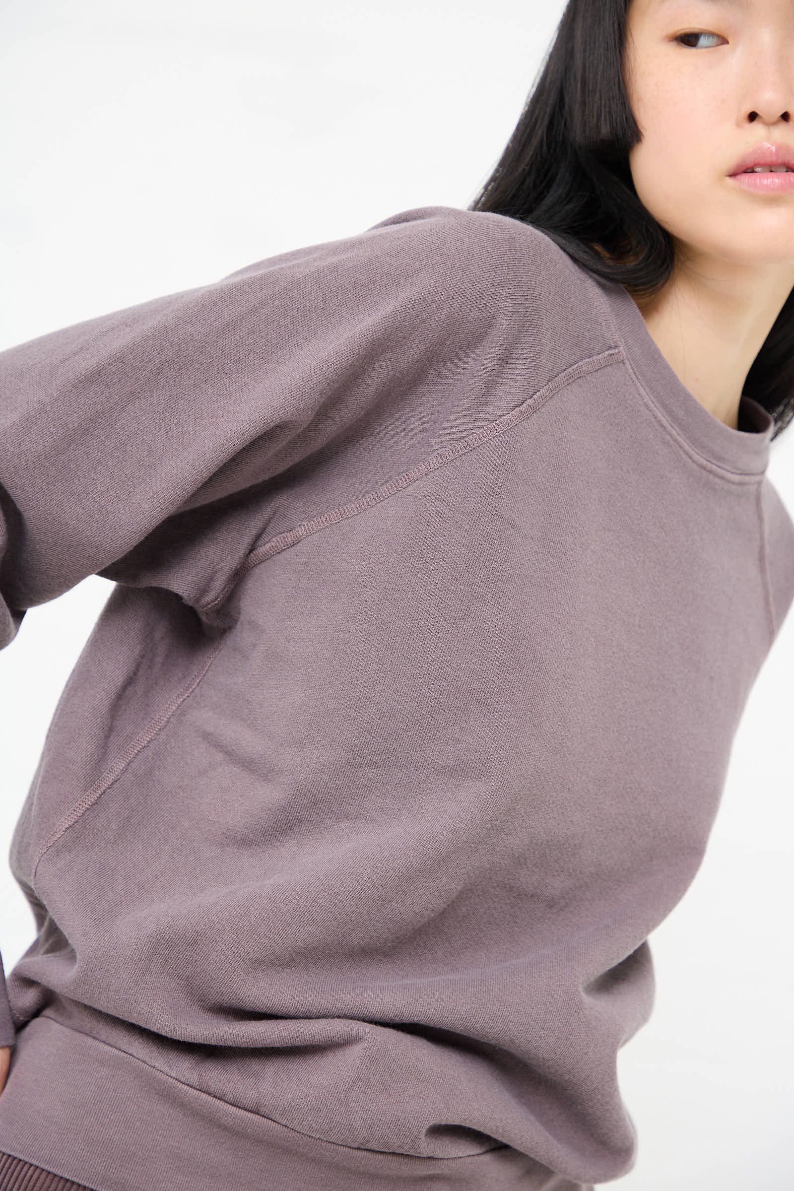 Person wearing a loose-fitting, long-sleeve Crewneck Sweatshirt in Tess Botanical by B Sides, partially cropped and set against a plain white background, crafted from soft French terry fabric.