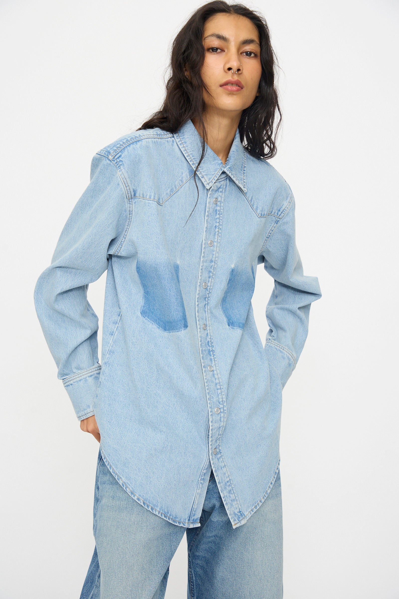 A person wearing the B Sides Liv Western Shirt in Park Wash with matching denim pants stands against a plain white background.