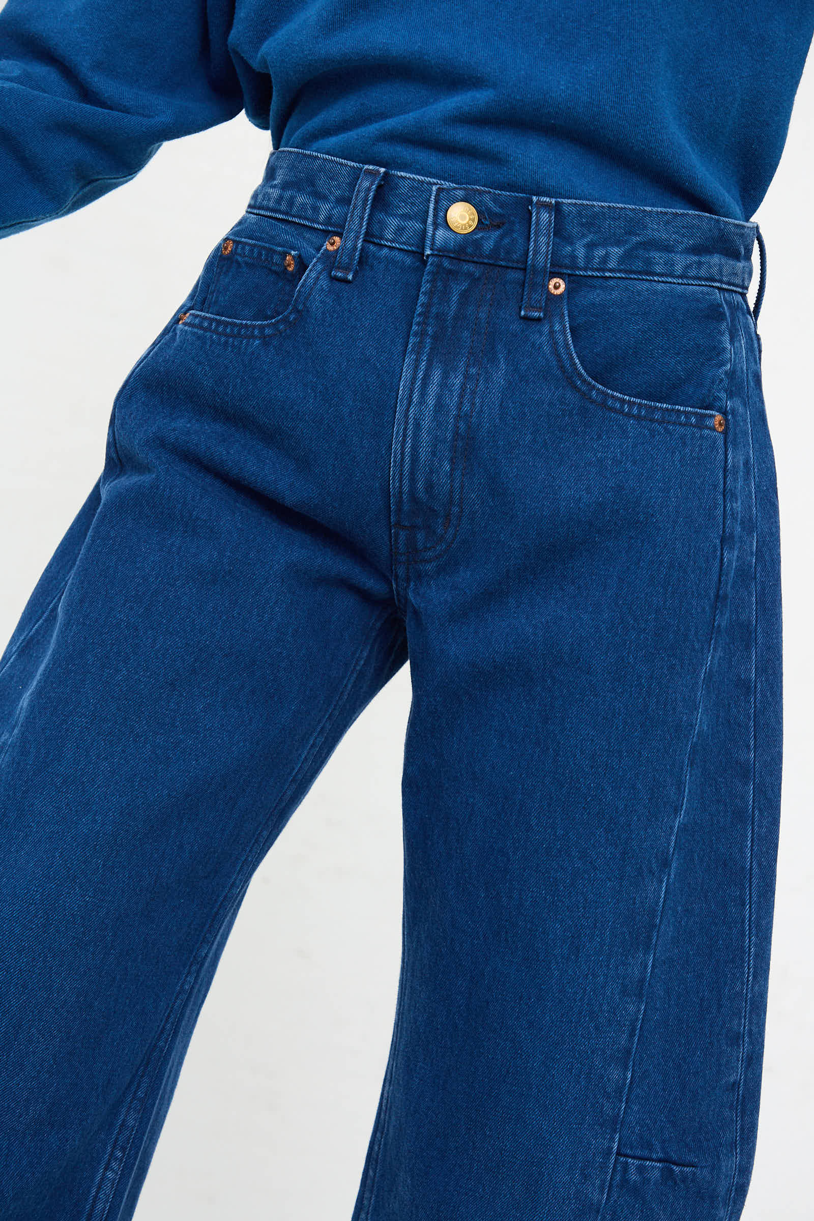 Individual dressed in the Relaxed Lasso Jean in Van Blue by B Sides, showcasing button and pocket details in a medium wash denim with a high-waisted relaxed fit.