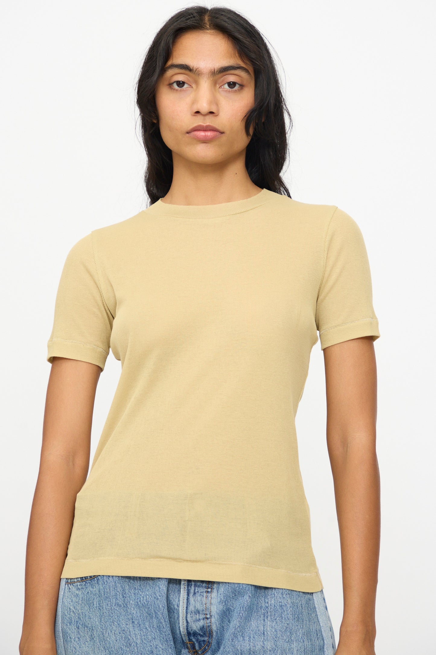 Model wears the B Sides Vivien Rib Tee in Honey with blue jeans, standing against a plain white background and facing the camera.