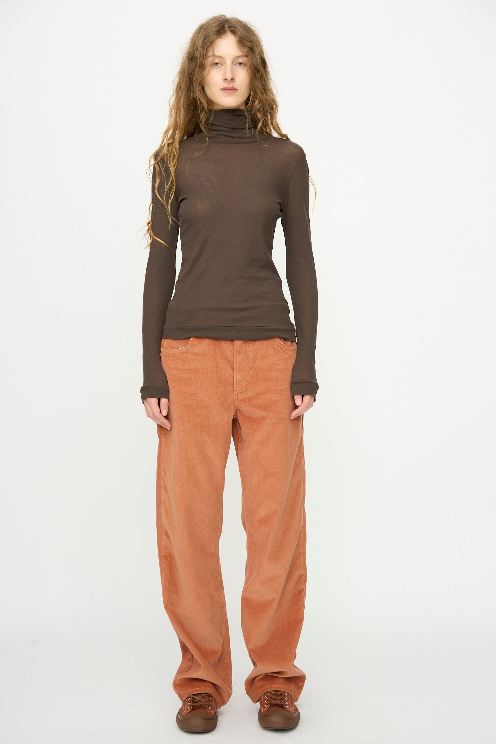 A person stands against a white background wearing the B Sides Bec Jean in Peach Tile.