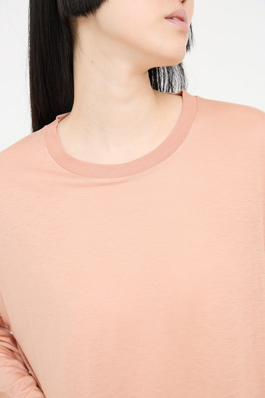 Close-up of a woman wearing a Yu Rose Bamboo Loose Long Sleeve Tee by Baserange.