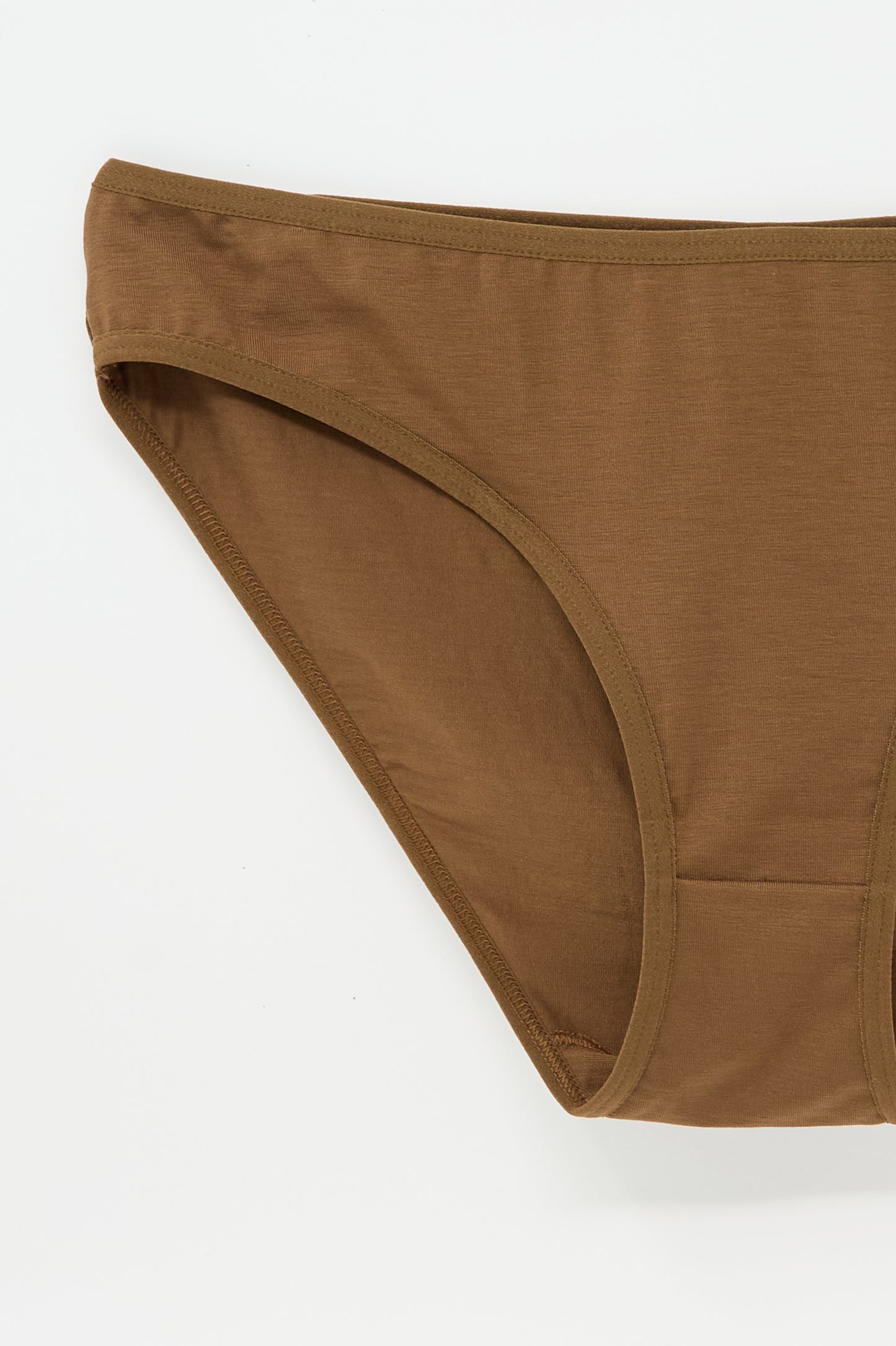 A close-up view of the Baserange Bell Pant in Ocular, showcasing the brown cotton fabric, side details, and elastic waistband trim.