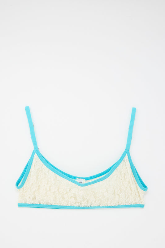 The Baserange Cotton Lace Musial Bra in Undyed and Turquoise features organic cotton with turquoise straps and blue trim, displayed flat on a white background.